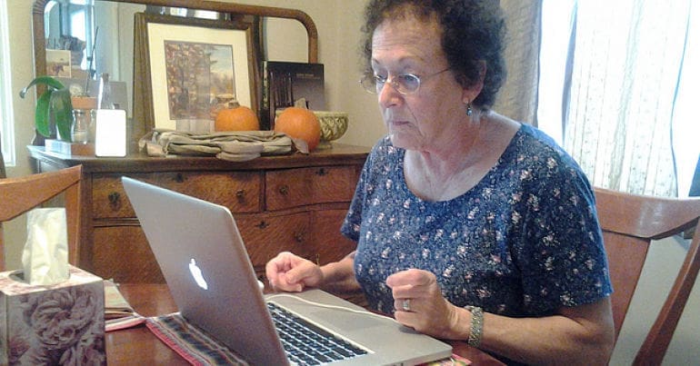An elderly woman using a computer