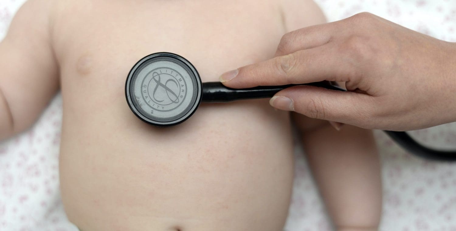 A stethoscope held up to a child's chest