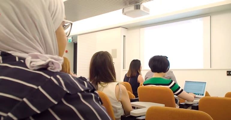 A group of people in a university lecture representing neurodiverse and autistic people who universities are failing