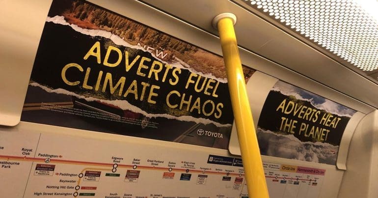 anti-ad protest banner on the London tube on Black Friday Cyber Monday