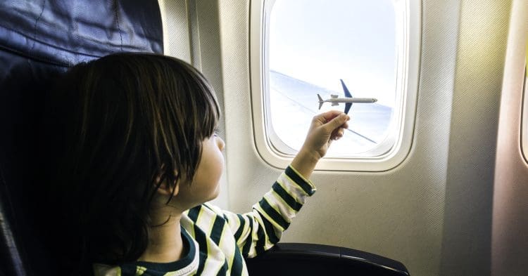 boy playing with model plane on a plane aerotoxic syndrome