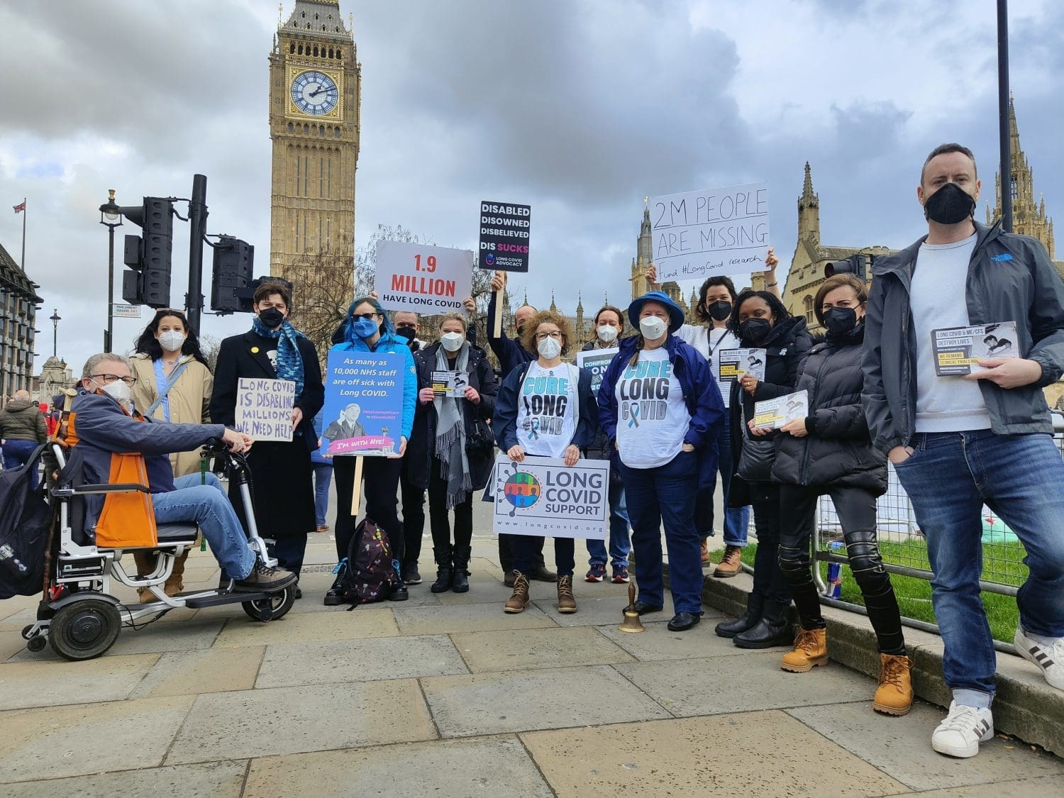Long Covid Awareness Day campaigners holding placards and signs with Big Ben in the background