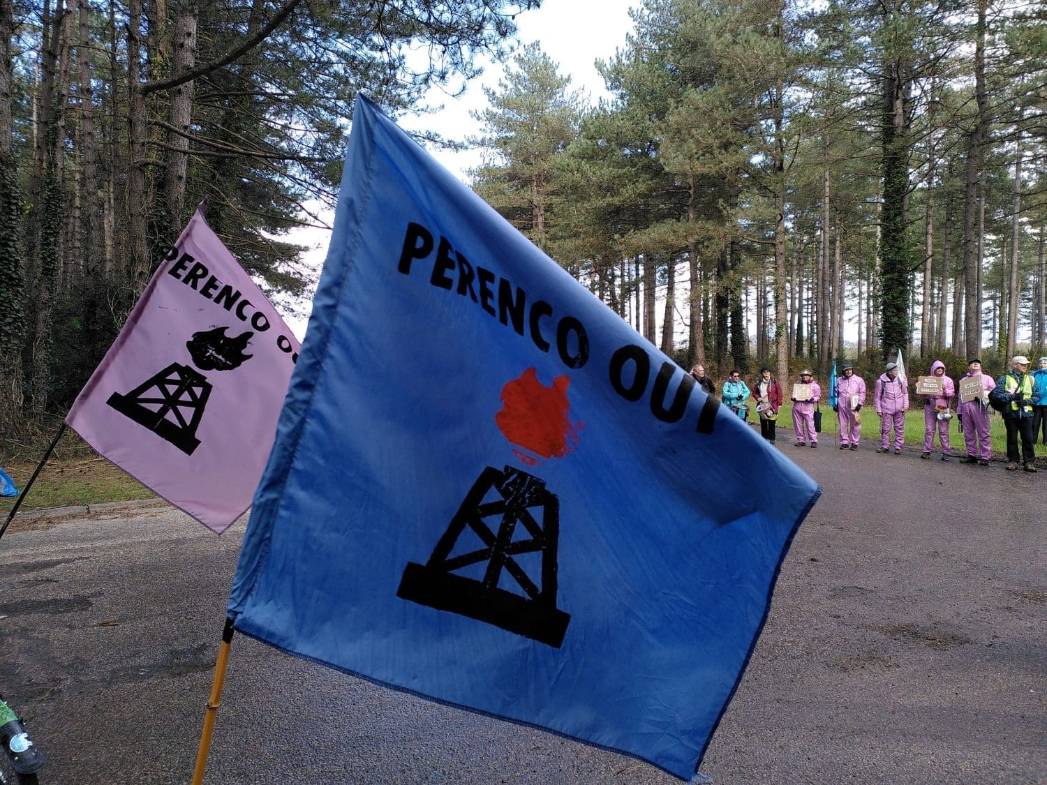 "Perenco Out" flags blow in the wind near the entrance to Wytch Farm.