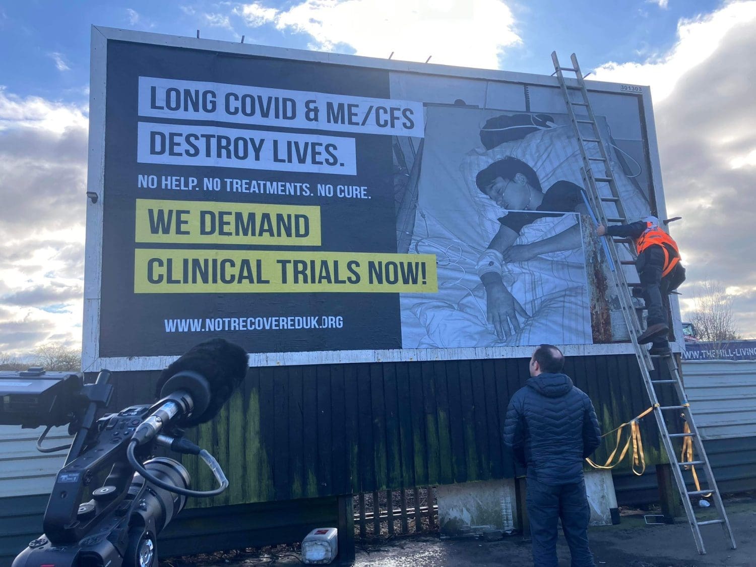 A billboard being put up that reads "Long covid and ME/CFS destroy lives. No help. no treatments. No cure. We demand clinical trials now. www.notrecovereduk.org"
