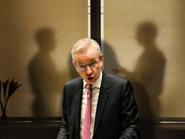 Michael Gove in front of two shadowy figures leaseholders
