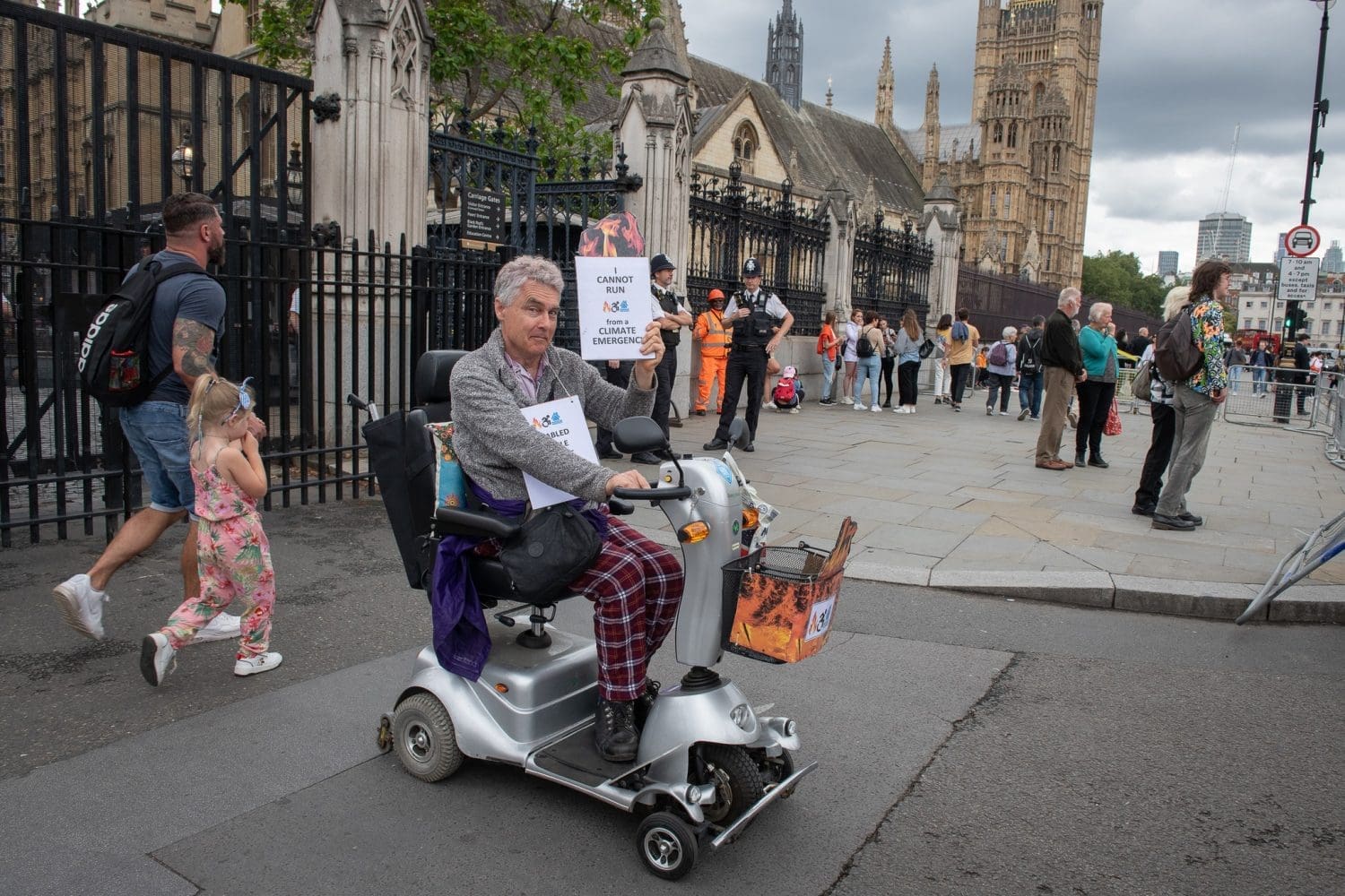 Neil Goodwin, a disabled man, protesting outside parliament in his mobility scooter
