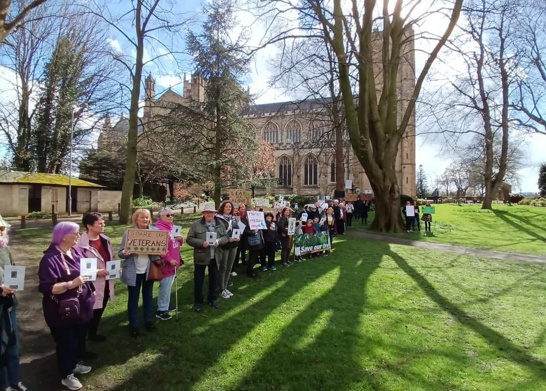 Save the Trees campaigners stand in a line across the green space, near the veteran beech tree at Ripon Cathedral
