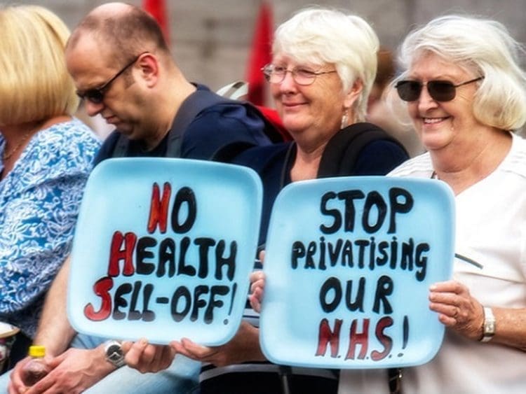 NHS privatisation protest two women holding placards EveryDoctor