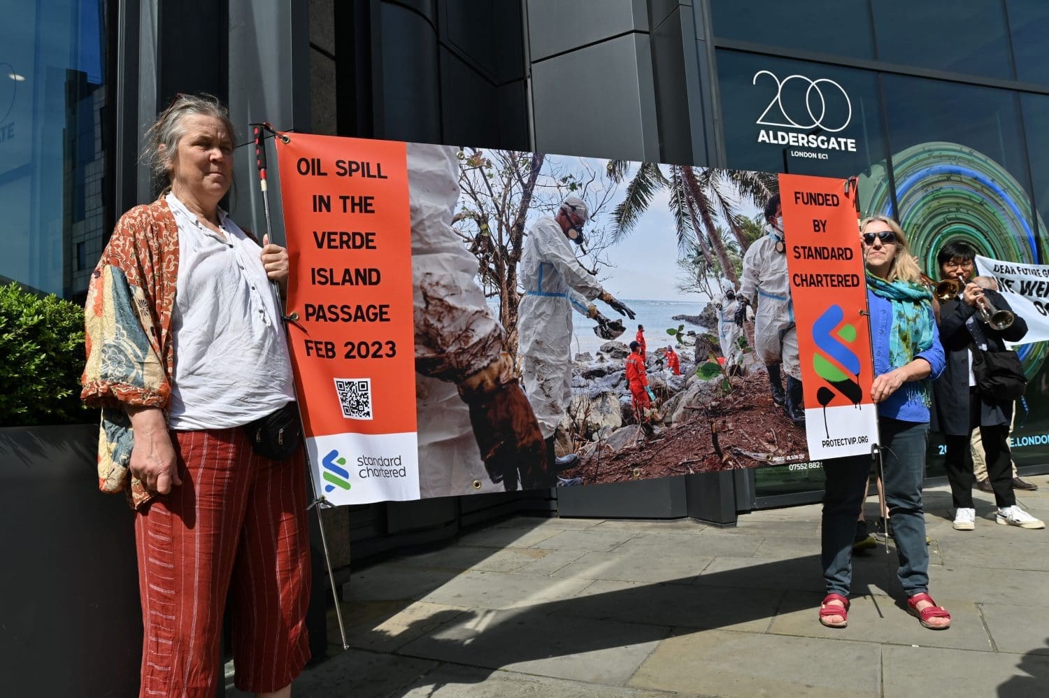 Protesters witha banner that reads: Oil spill in the Verde Island Passage Feb 2023 - Funded by Standard Chartered.