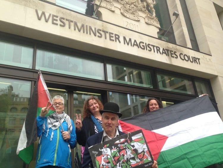 Neil Goodwin with supporters outside court with the Palestinian flag Israel