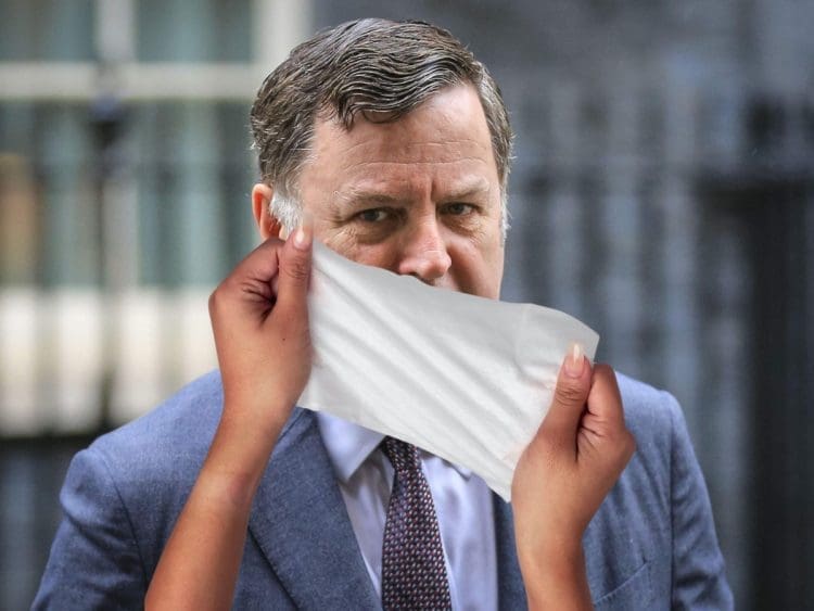 Mel Stride with a wet wipe over his face DWP