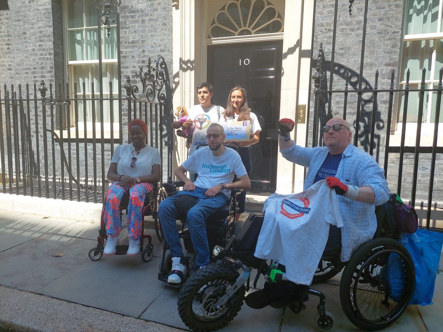 a group of disabled people outside 10 Downing Street